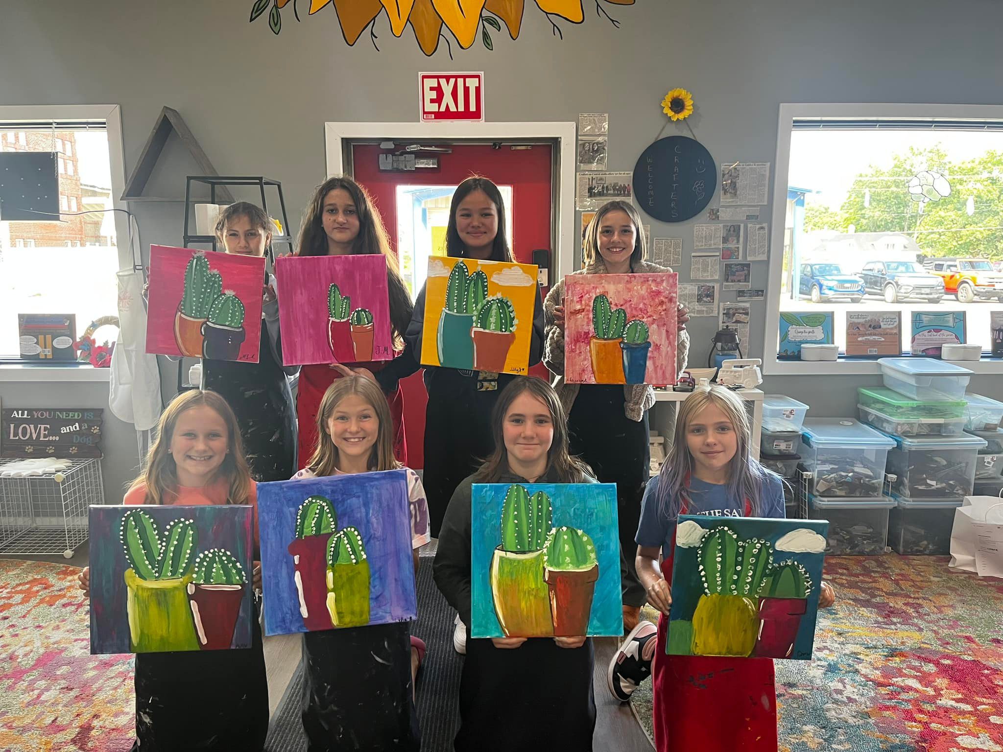 Girls showing off cactus paintings