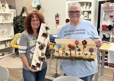 colorful pinecone art on wood background at Crafters on Central